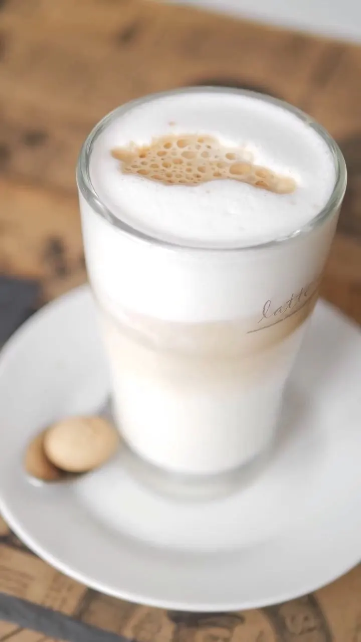 Latte Macchiato im Glas, für ein Café-Reel in Szene gesetzt